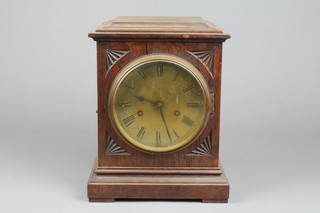 An Edwardian striking bracket clock with silvered dial and Roman numerals contained in a carved oak case 