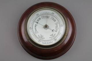 An aneroid barometer with silvered dial contained in a mahogany case 10 1/2"