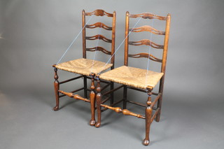A pair of pierced elm ladderback chairs with woven rush seats, raised on club supports, 1 with old repairs to ladderback