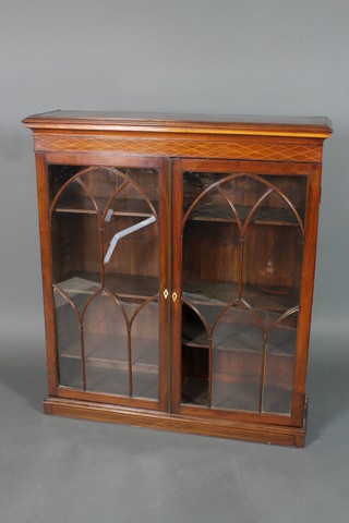 A Georgian inlaid mahogany bookcase with moulded and inlaid cornice, the interior fitted adjustable shelves enclosed by astragal glazed panelled doors with ivory diamond escutcheons, raised on an associated inlaid mahogany base 50"h x 44"w x 12"d