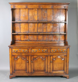 A Georgian style oak dresser, the raised back with moulded cornice fitted 2 shelves, the base fitted 3 drawers above a triple cupboard enclosed by arched panelled doors, raised on bracket feet 80"h x 64"w x 19"d 