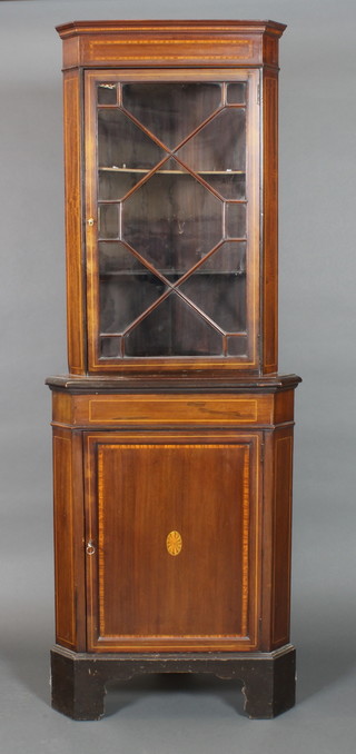 An Edwardian inlaid mahogany double corner cabinet, the upper section with moulded cornice, the interior fitted shelves enclosed by astragal glazed panelled doors, the base fitted a double cupboard enclosed by a panelled door, raised on bracket feet 73"h x 27"w x 14"d 