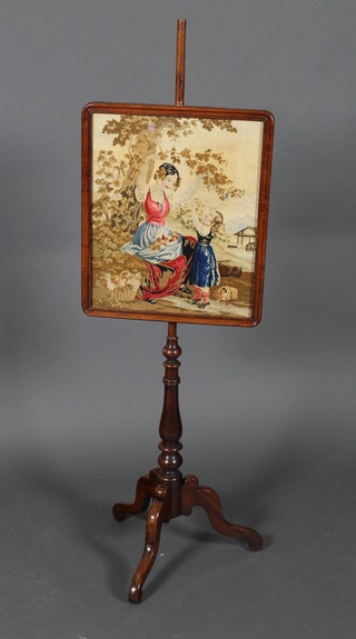 A Victorian mahogany pole screen with rectangular wool work banner decorated a figure of a mother and child, raised on a pillar and tripod base, 55" overall 