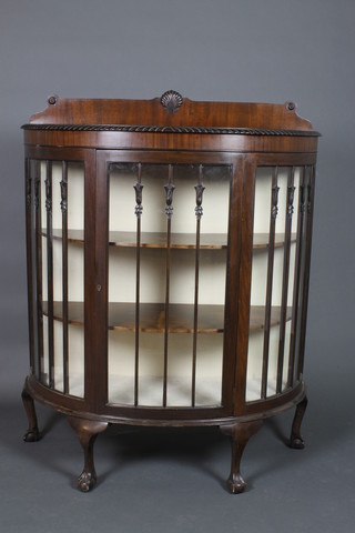 A 1920's Chippendale style mahogany bow front display cabinet, the raised back carved a shell, the interior fitted shelves enclosed by astragal glazed doors, raised on cabriole ball and claw supports 52 1/2"h x 42"w x 17 1/2"d 