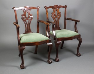 A pair of Chippendale style mahogany carver chairs with pierced slat backs, the upholstered drop in seats of serpentine outline, raised on cabriole supports