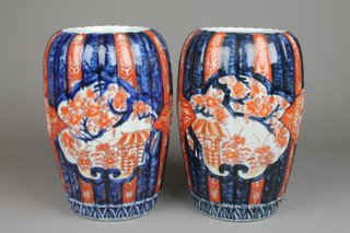 A pair of 19th Century oviform ribbed Imari vases, the blue and red grounds with panels of pavilions, flowers and motifs 9" 