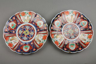 A pair of late 19th Century scalloped Imari dishes with panels of dogs amongst flowers with a formal floral centre 10" (f)