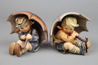 A pair of Goebel figures of a seated boy and girl with umbrellas 5" 