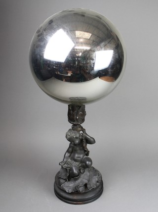A silver Witches ball on a bronze sconce supported by spelter figure 26" 