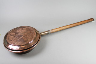 A copper warming pan with turned wooden handle 