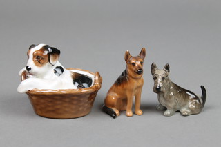 A Royal Doulton figure of a terrier in a basket HN2587 3", a seated Alsatian K13 3" and a seated terrier K18 2" 