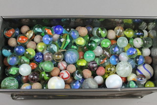 A quantity of marbles contained in a metal box