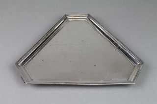 A triangular silver salver with simple reeded rim on scroll feet with presentation inscription, Birmingham 1932, approx. 530 grams  