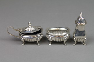 A silver 3 piece demi-fluted condiment set on pad feet, Birmingham 1976, approx. 114 grams