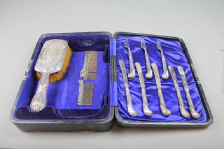 A set of 8 silver filled pistol butt butter knives, a repousse brush and comb (f)