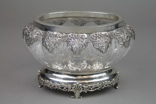 An Edwardian silver mounted cut glass lobed bowl, the pierced collar with formal scrolling flowers, the raised base with flower heads and scroll feet, London 1909, 7 3/4" 