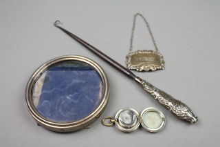 A silver handled button hook, photograph frame, spirit ladle and a metal sovereign case