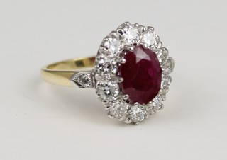 An 18ct yellow gold ruby and diamond cluster ring, the centre stone approx. 2ct, surrounded by 10 brilliant cut diamonds with diamond set shoulders, approx 1.25ct, size O 1/2