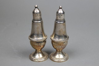 A pair of Sterling silver pepperettes with weighted bottoms and glass interiors 5 1/2" 