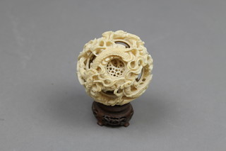 A Chinese carved ivory concentric ball decorated with dragons and scrolls 2" (f) on a hardwood stand