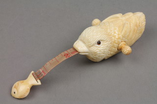A modern carved bone tape measure in the form of a crouching bird