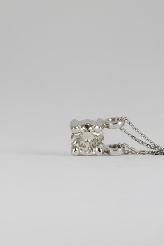 An 18ct white gold claw set diamond pendant, approx. 0.4ct on a ditto chain