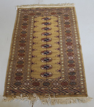 A yellow ground Bokhara rug with 10 octagons to the centre with multi-row borders, some damage to the edge 50" x 31"  
