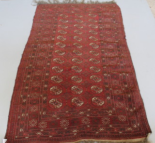 A red ground Afghan rug with 36 octagons to the centre 81" x 47 1/2" 