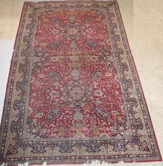 A red and blue ground Persian rug with central medallion, decorated animals amidst flowers, signed 194" x 120"  