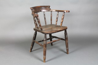 An elm smokers elbow chair with solid seat and H framed stretcher, raised on turned supports 