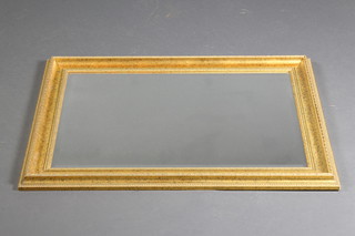 A rectangular bevelled plate wall mirror contained in a decorative gilt frame 35"h x 26"w