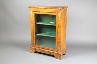 A Victorian figured walnut pier cabinet, fitted shelves enclosed by a glazed panelled door with gilt metal mounts 40"h x 30"w x 13"d