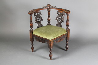 A Georgian carved walnut corner chair with pierced vase shaped slat to the back, decorated double headed eagles, with upholstered drop in seat on turned fluted supports