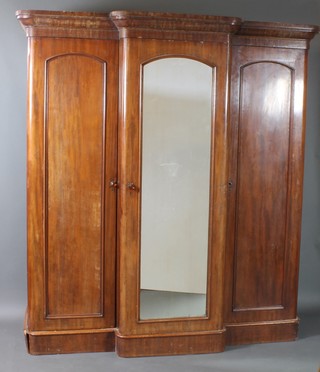 A Victorian mahogany triple wardrobe with moulded cornice, the centre section enclosed by arch panelled doors flanked by a pair of cupboards enclosed by arch panelled doors 81 1/2"h x 75"w x 26"d 