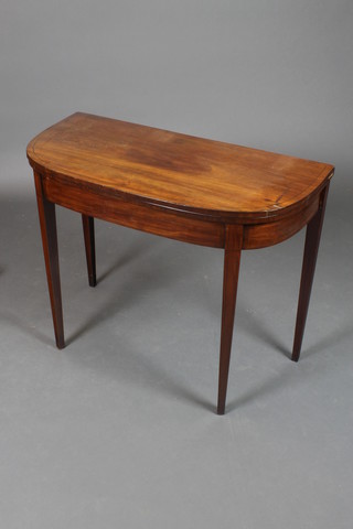 A Georgian mahogany demi-lune card table with cross banded top and ebonised stringing, raised on square tapered supports 28 1/2"h x 35"w x 17"d 