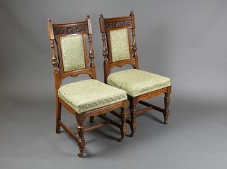A pair of Victorian carved oak high back chairs with upholstered seats and backs, raised on turned and fluted supports with H framed stretcher, (1 with old break to the back)