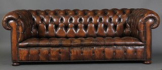 A Chesterfield upholstered in brown buttoned back leather 28"h x 88"w x 35"w
