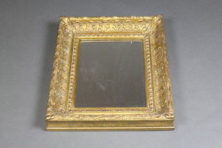 A rectangular bevelled plate mirror contained in a decorative gilt frame 23" x 19"