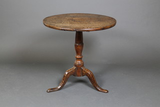 A 17th/18th Century oak circular snap top wine table, raised on a turned column and tripod base 24 1/2"h x 25" diam.  