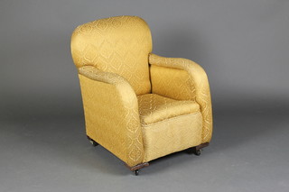 A 1930's childs armchair upholstered in yellow material, raised on casters 