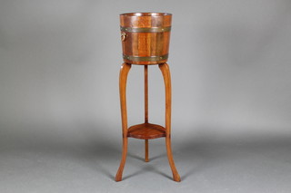 A circular coopered oak and mahogany jardiniere stand with undertier, raised on cabriole supports 40"h x 12"d