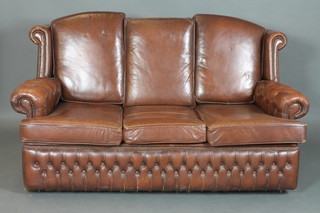 A 3 seat Chesterfield style settee upholstered in brown buttoned leather 26"h x 70"w 