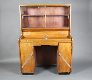 An Art Deco walnut students bureau bookcase, the upper section fitted shelves and 2 secret drawers, the base fitted a secretaire section above 1 long drawer flanked by a pair of cupboards 58"h x 42"w x 18 1/2"d 