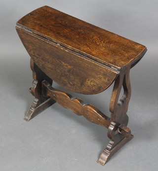 An oak oval drop flap occasional table raised on pierced standard end supports with H framed stretcher 20"h x 7" when closed x 24" when opened by 21 1/2"l, missing peg to bottom leg