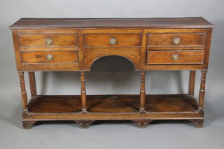 An 18th Century oak dresser base fitted 1 long drawer flanked by 4 long drawers with replacement ring drop handles, with a pot board, raised on turned and block supports 