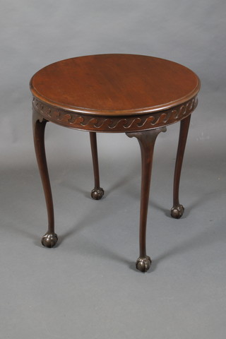 A circular Chippendale style mahogany occasional table with carved apron, raised on cabriole, ball and claw supports 28 1/2"h x 27" diam.