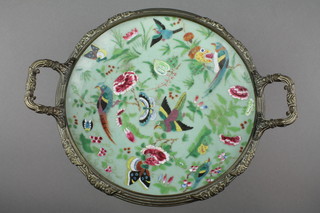 A Celadon dish decorated with birds and insects amongst flowers, now mounted in a gilt metal stand with twin handles and splayed foot 13" 