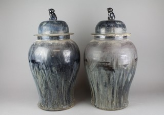 A pair of 20th Century Chinese slip glaze baluster vases and covers with lion finials 21" 