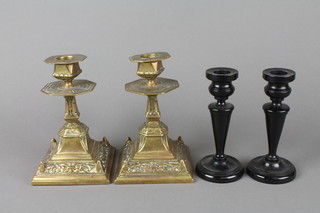 A pair of 19th Century brass candlesticks raised on square bases 6 1/2" and a pair of turned ebony candlesticks 5" 