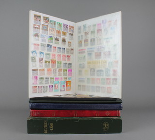 A stock book of German stamps, a red stock book of World stamps and 3 further stock books
